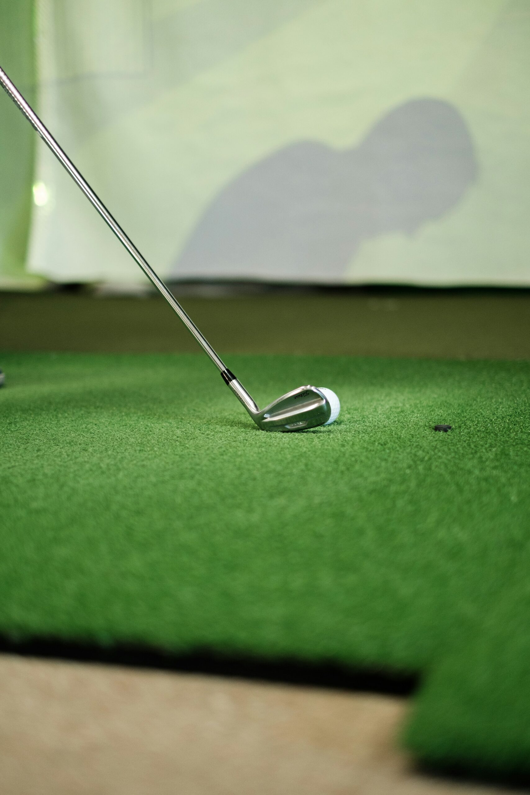 Golfklubba och golfboll på en grön puttinggreen